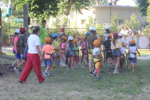 Bambini con casco e imbracatura che iniziano il percorso di apprendimento per le attrazioni di Rimini Avventura